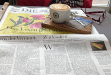 Zeitunglesen und Belohnungscappuccino im Café.